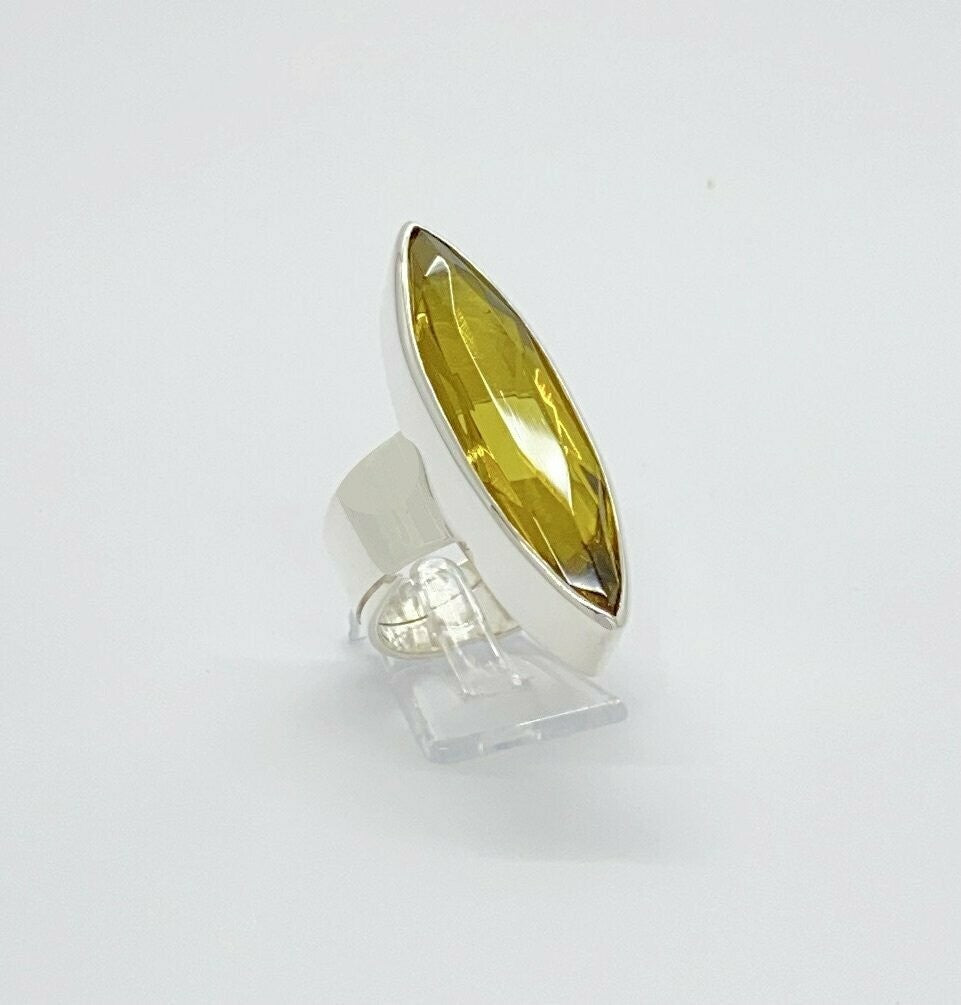 Silberring mit goldbraunem Obsidian 1 × 4 cm auf Klarsichtständer.