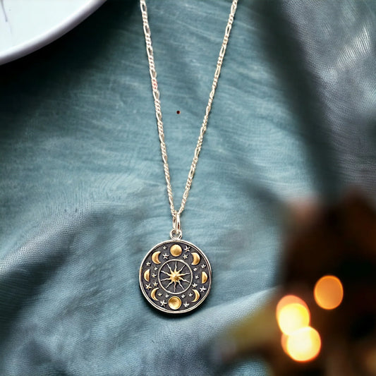 Silberkette mit vergoldetem Mondphasen-Anhänger von MadamLili auf blauem Stoff, Medaillon mit Mondphasen und Sternen