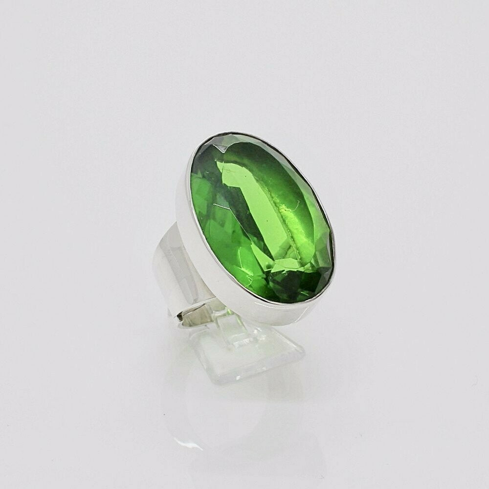 Silver ring featuring emerald-green obsidian oval 2x3 cm, a modern statement piece.