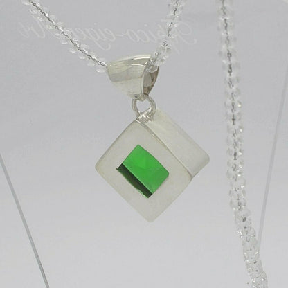 Silver pendant with emerald-green obsidian square (2x2 cm) set in a clear square setting on a chain.