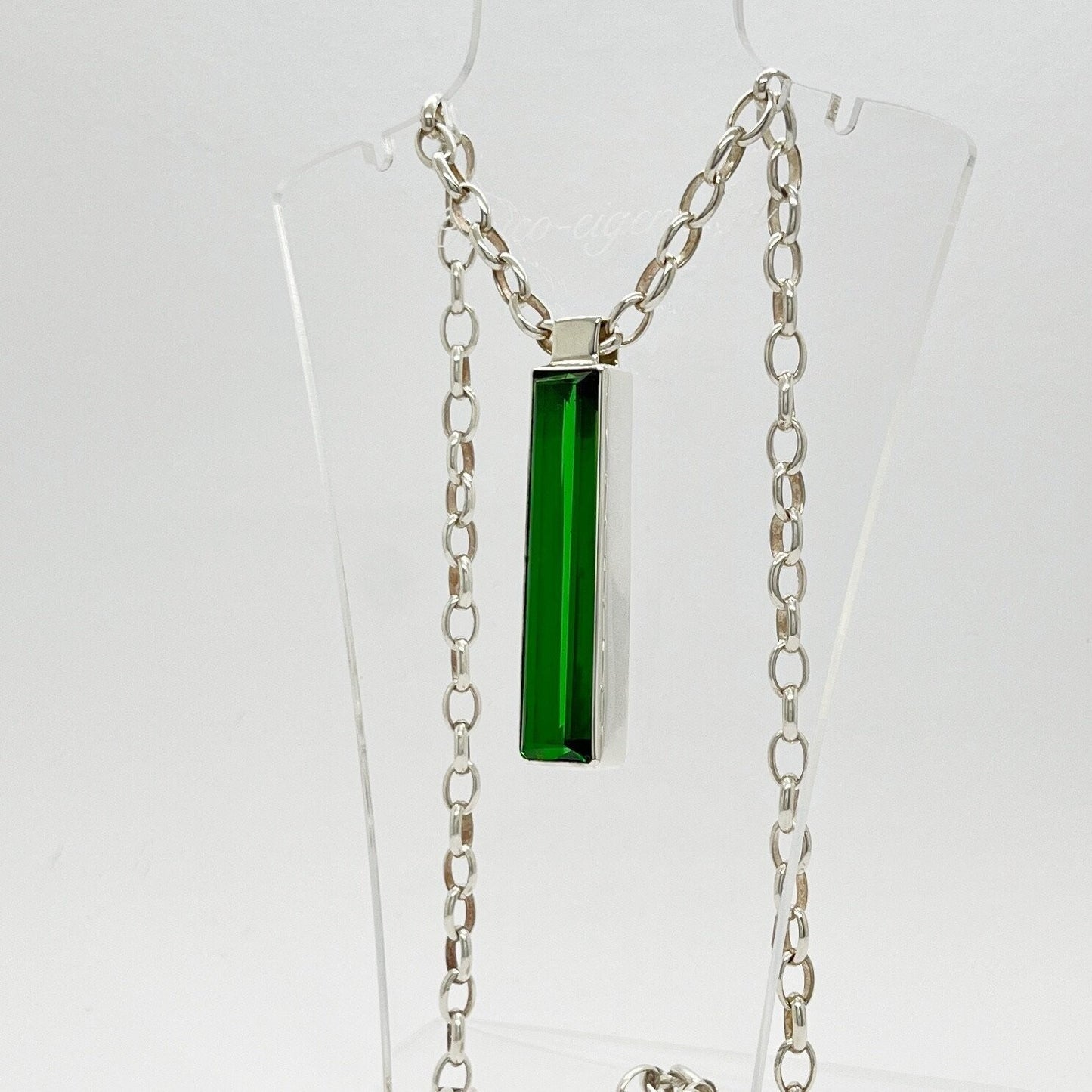 Silver rectangular pendant with emerald-green obsidian, 1x5 cm, on a chain.