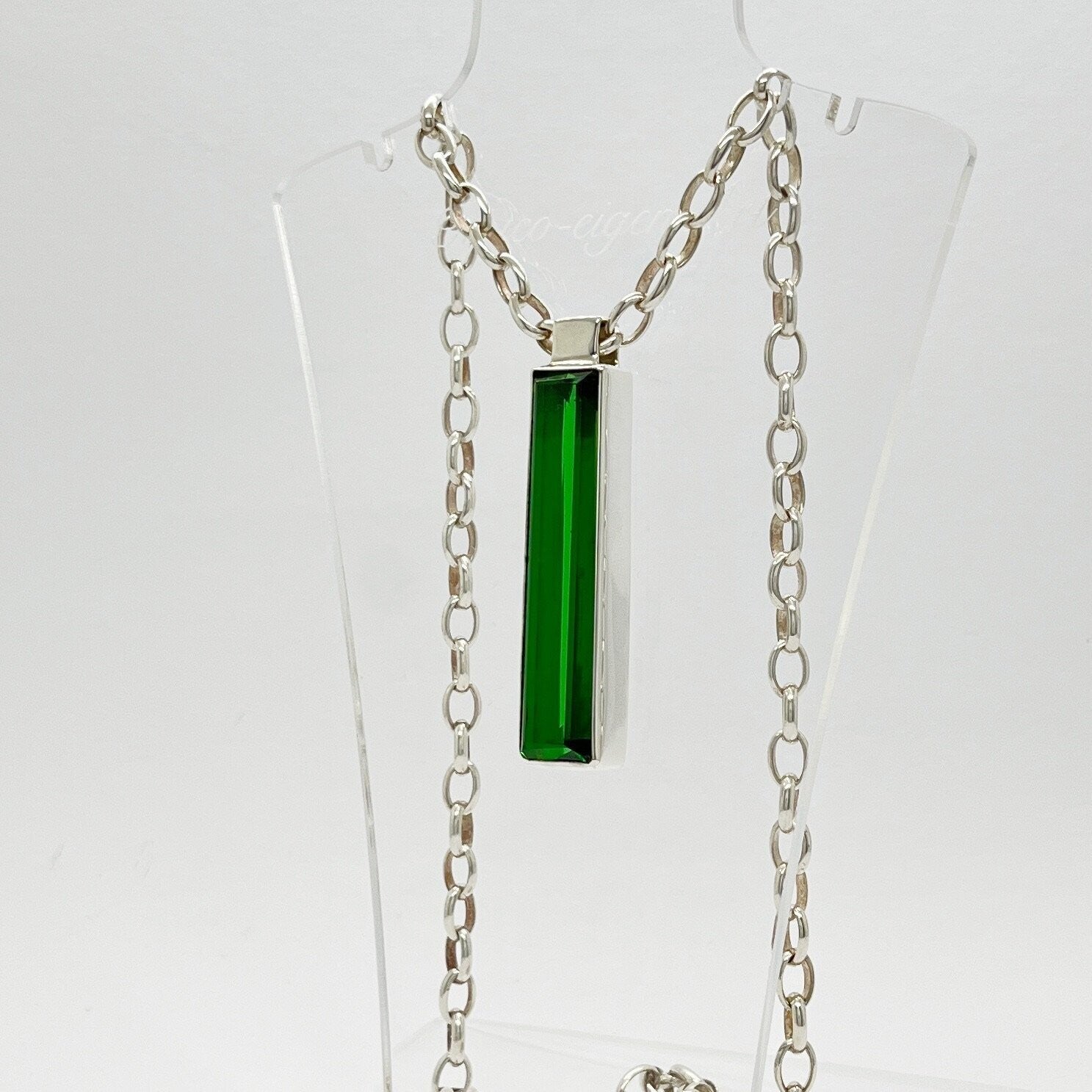 Silver rectangular pendant with emerald-green obsidian, 1x5 cm, on a chain.
