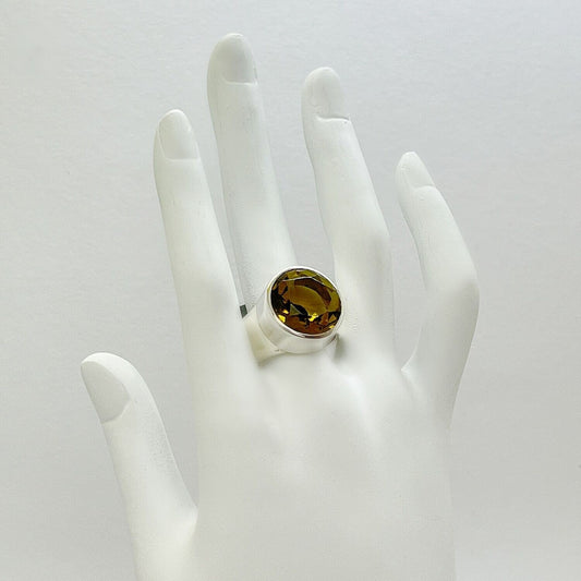 Silberring mit goldbraunem Obsidian, runder facettierter Stein Ø ca. 1,5 cm in Silberfassung.