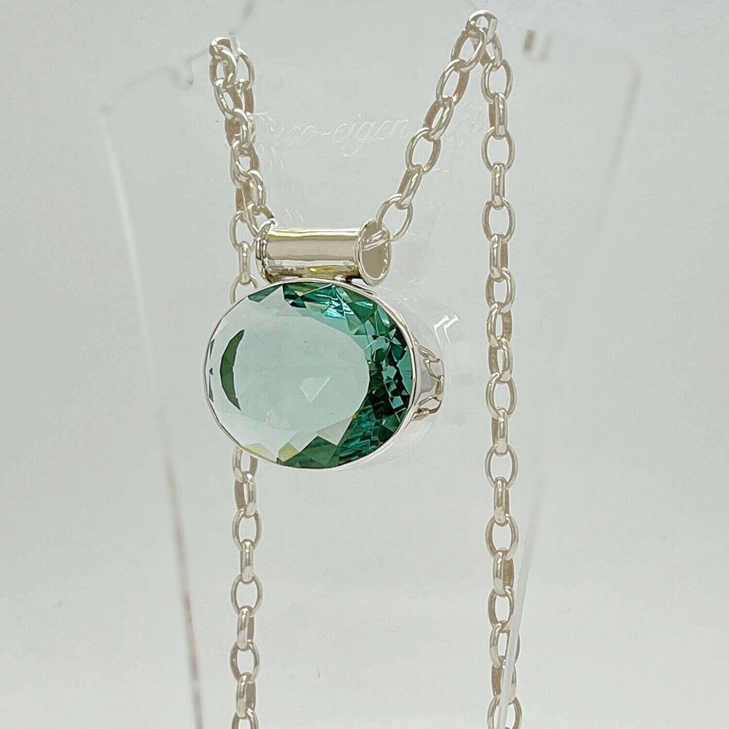 Silberanhänger mit ovalem meerblauem Obsidian, facettierter Stein, 3,5 × 4,5 cm, an Silberkette.