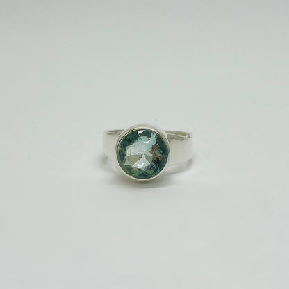 Silberring mit rundem meerblauen Obsidian (Ø ca. 1 cm) in glatter Silberfassung, facettiert.