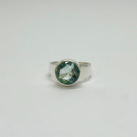 Silberring mit rundem meerblauen Obsidian (Ø ca. 1 cm) in glatter Silberfassung, facettiert.