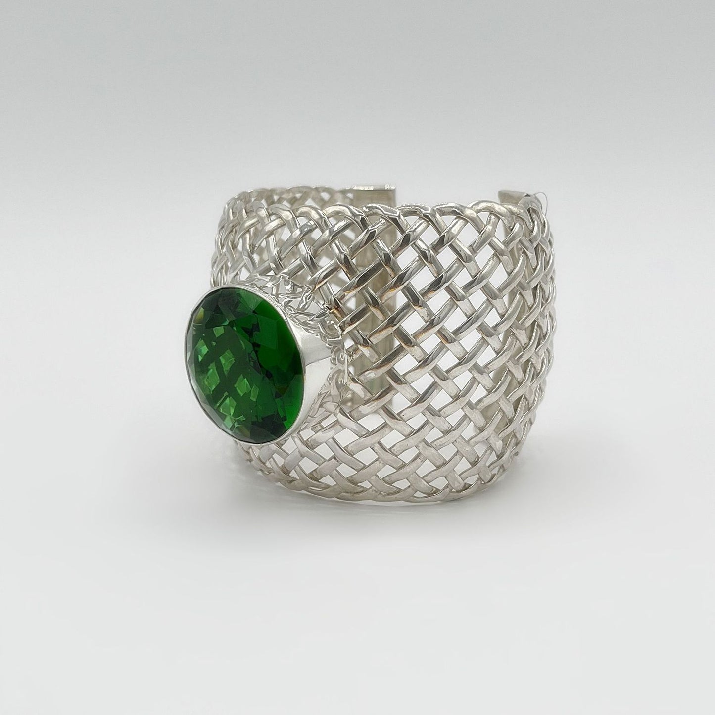 Armspange aus 925er Silber mit geflochtenem Muster und grünem Obsidian, facettiert.