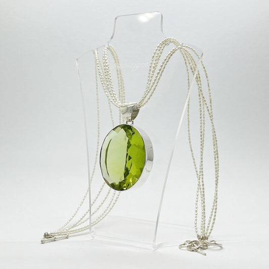 Ovaler lichtgrüner Obsidian-Anhänger in Silberfassung, 3,5 × 4,5 cm, an einer mehrreihigen Perlenkette.