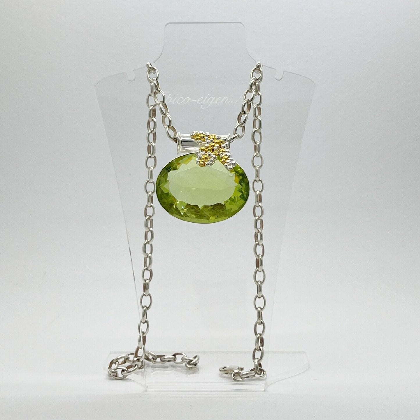 Ovaler, facettierter Obsidian lichtgrün als Anhänger mit Gold- und Silberblasen-Elementen an silberner Kette