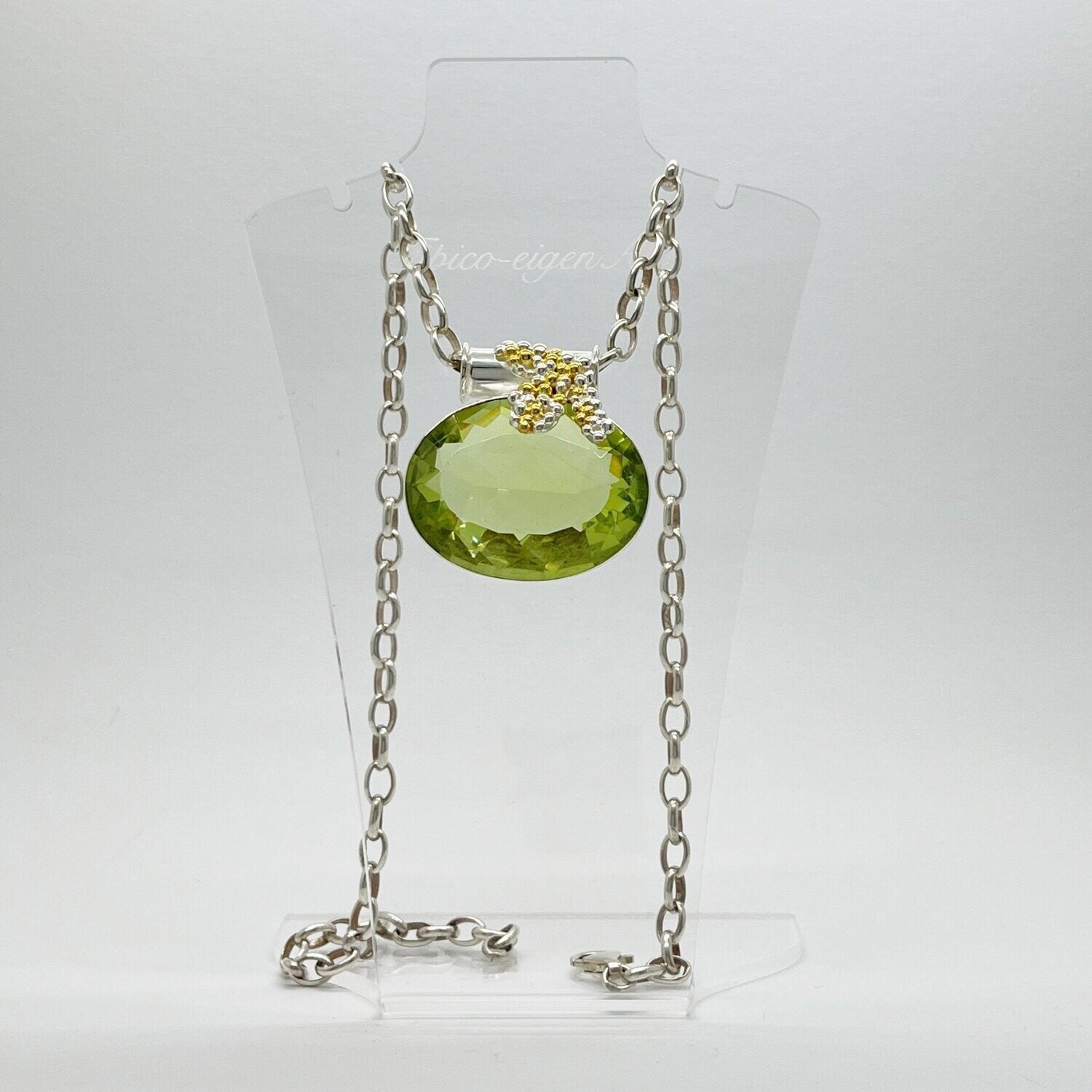 Ovaler, facettierter Obsidian lichtgrün als Anhänger mit Gold- und Silberblasen-Elementen an silberner Kette