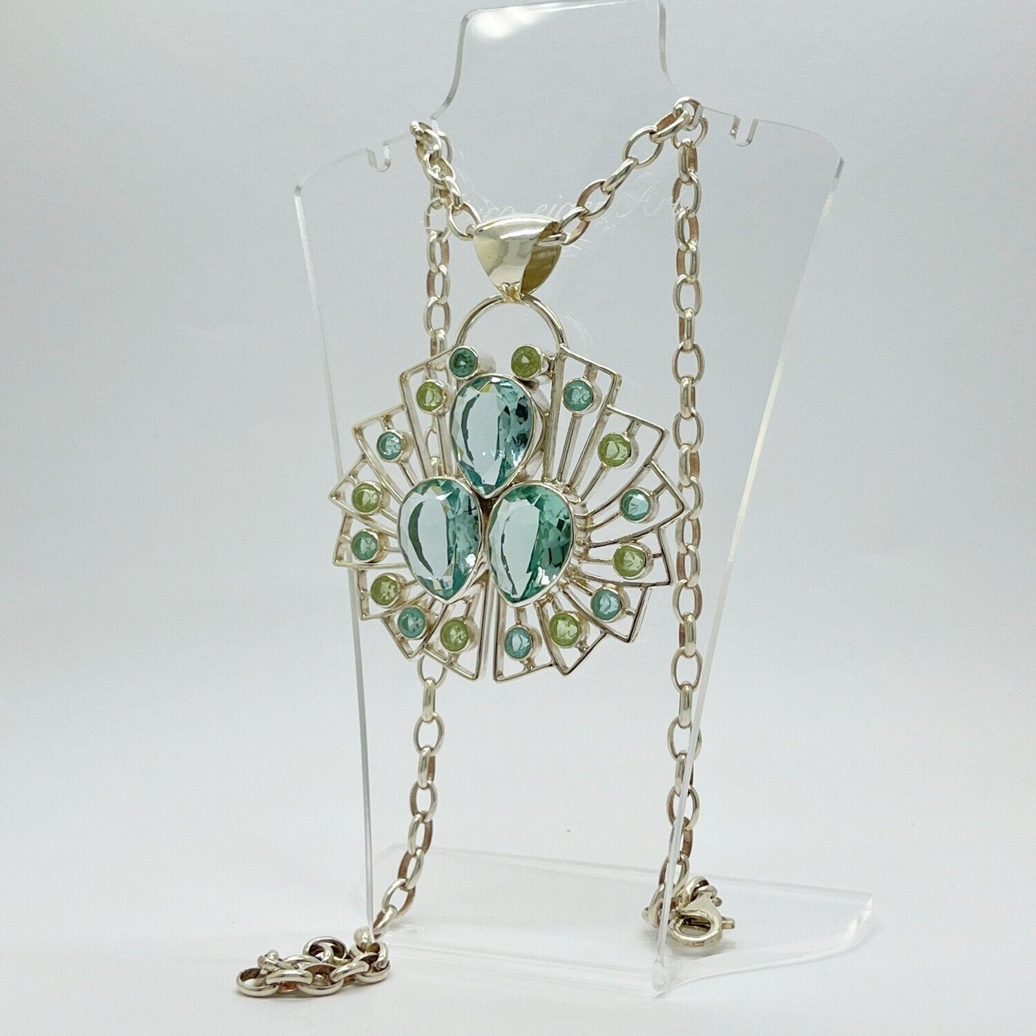 Anhänger Sea Rose: radialer Blütenrahmen aus Obsidian meerblau und lichtgrün, facettierte Tropfen- und Rundsteine.