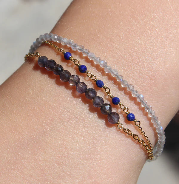 Vergoldetes Silberarmband mit Granat & Labradorit an Handgelenk, kombiniert mit weiteren Perlenarmbändern