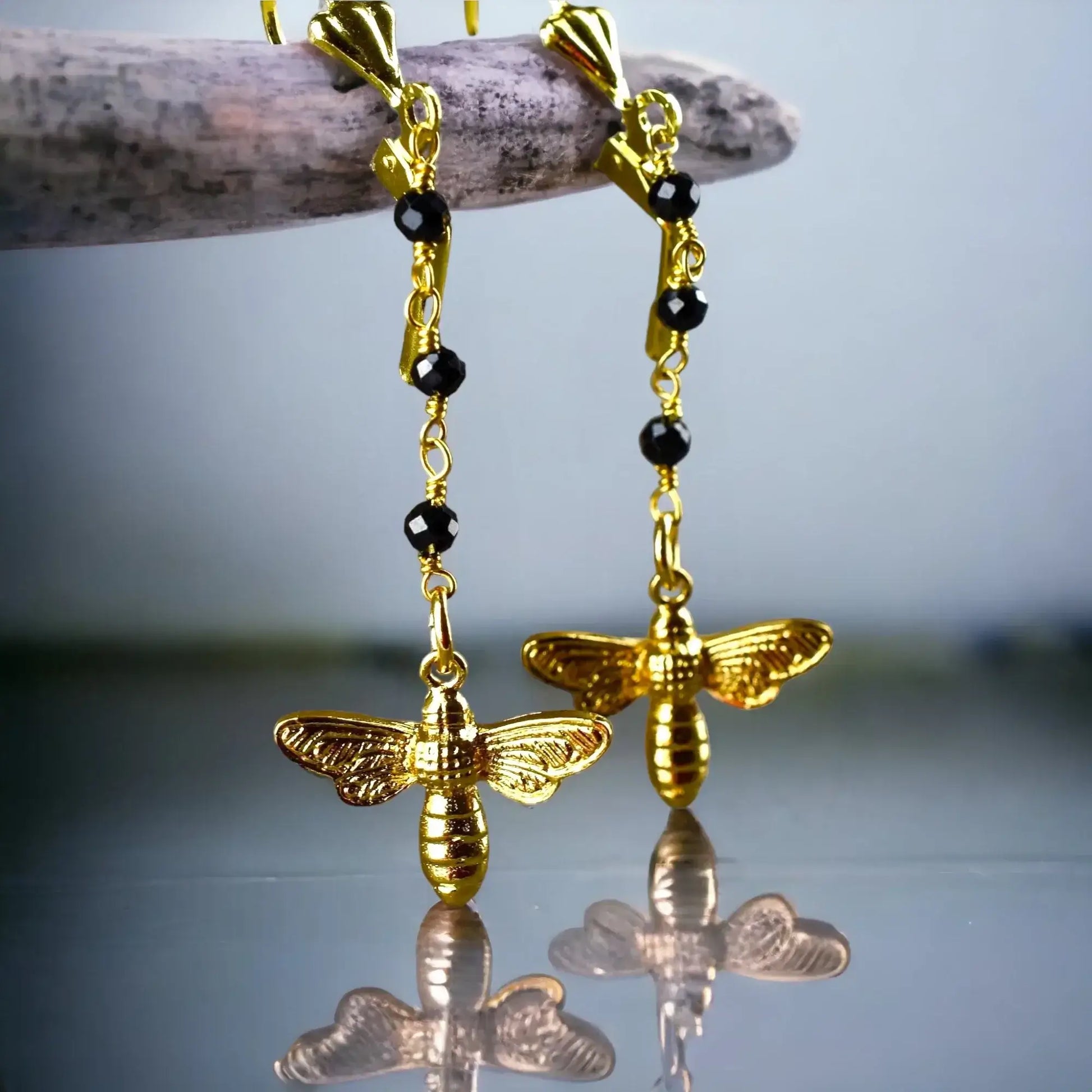 Goldene Bienen-Ohrringe mit schwarzem Onyx und schwarzen Perlen an Goldkette.