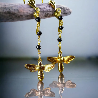 Goldene Bienen-Ohrringe mit schwarzem Onyx und schwarzen Perlen an Goldkette.