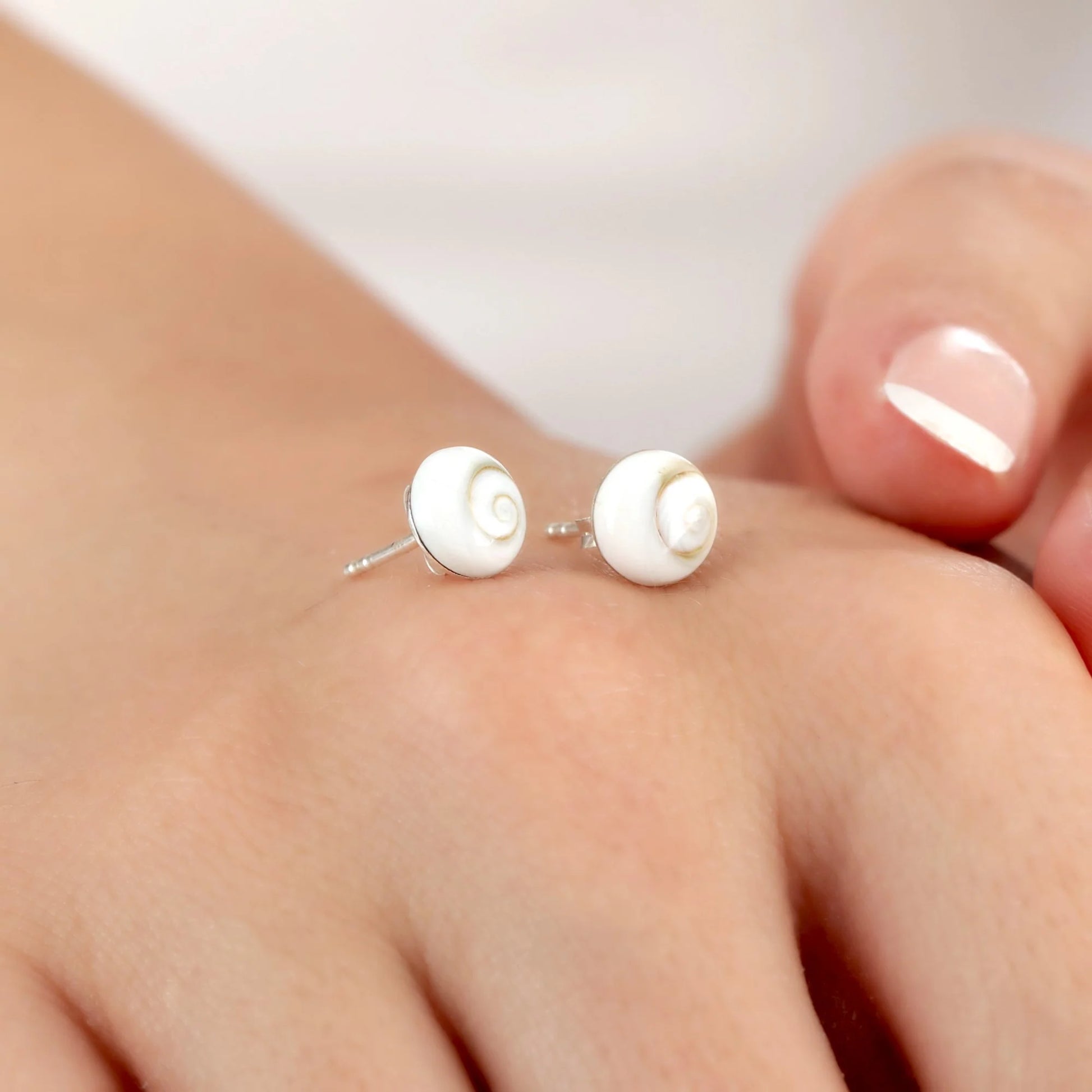 Zwei Muschel-Ohrstecker aus 925er Silber auf Silberbasis mit echten Shiva Eye Muscheln, handgefertigt in Deutschland