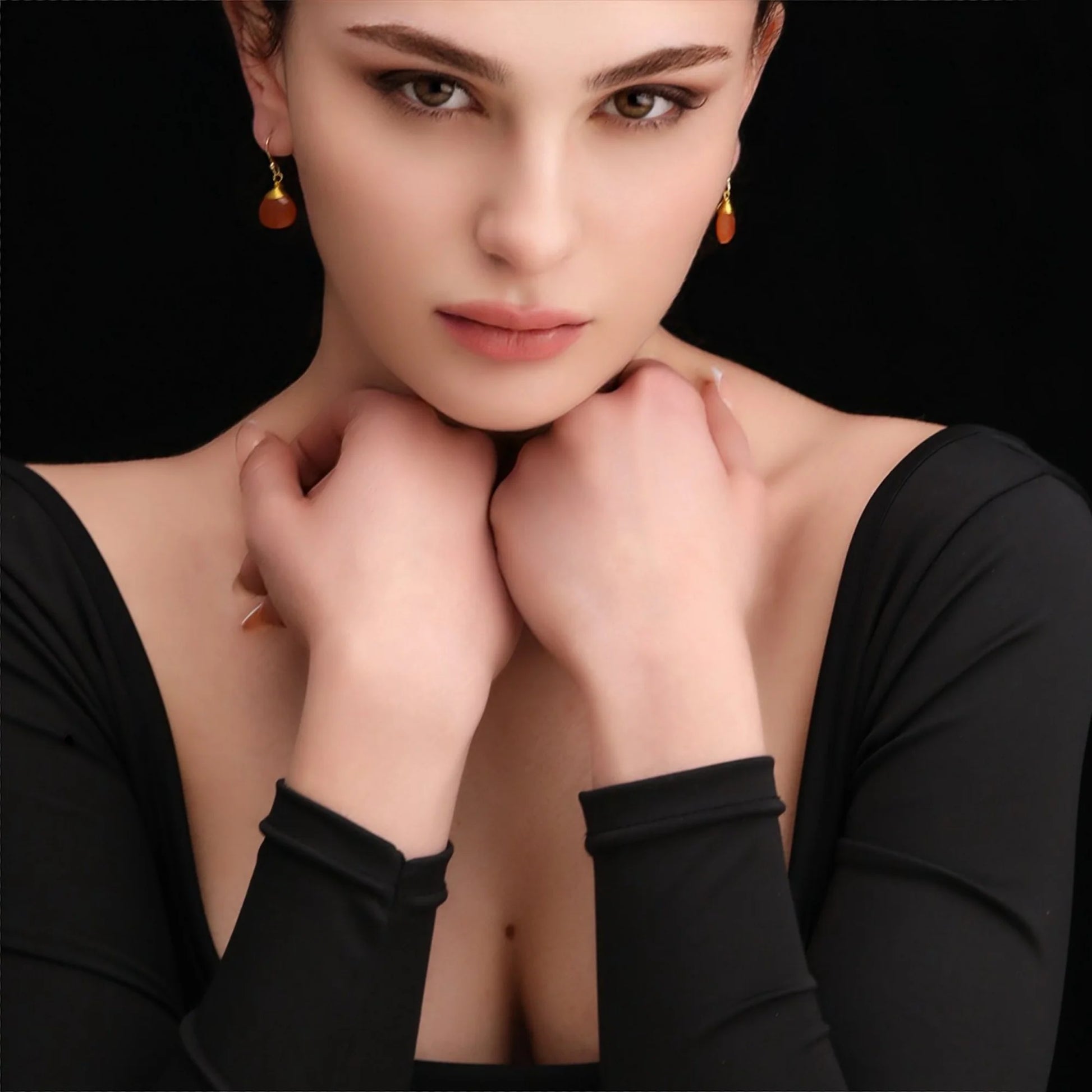 Frau trägt vergoldete 925er Silber Ohrringe mit Karneol-Tropfen in Orange.